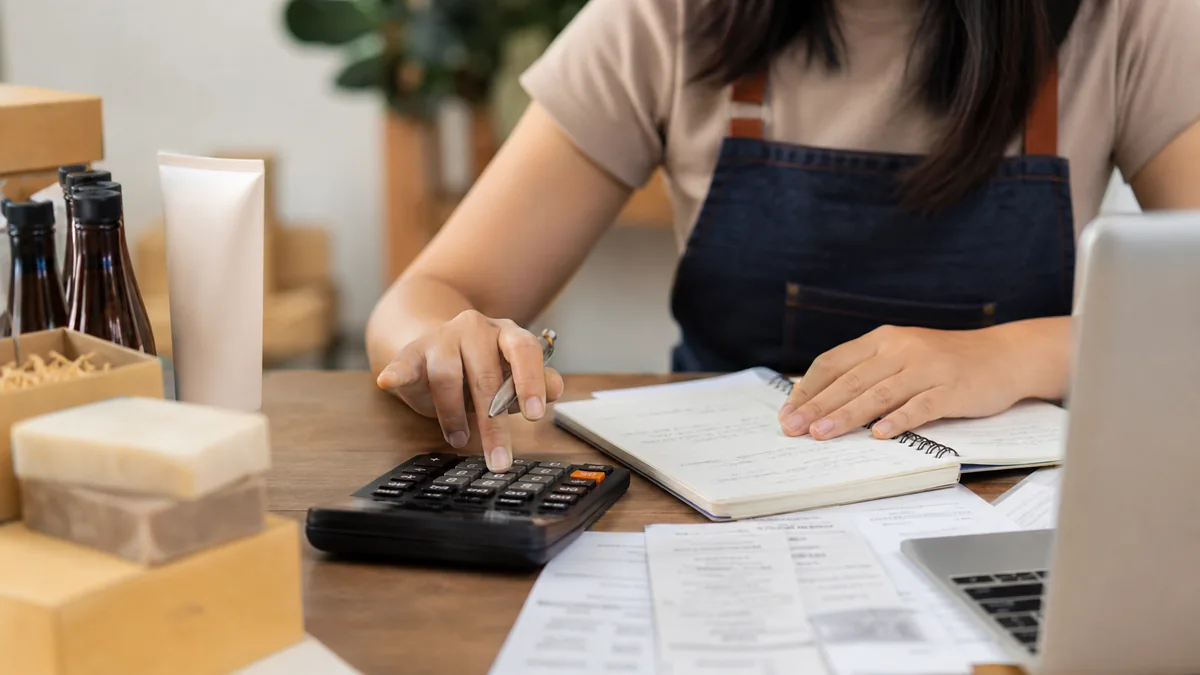 Small business budget planning desk with receipts and laptop